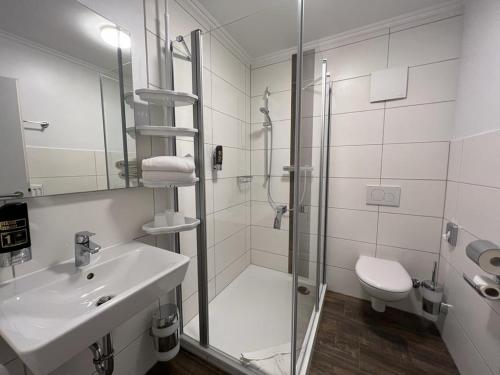 La salle de bains est pourvue d'une douche, d'un lavabo et de toilettes. dans l'établissement Gästehaus Blauth, à Cuxhaven