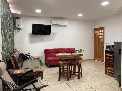 a living room with a red couch and a table at Palmas de Chahue in Santa Cruz Huatulco