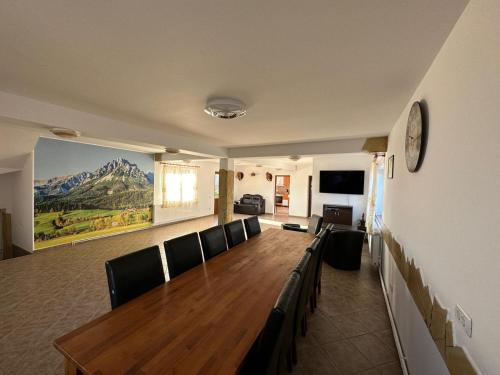 a conference room with a long wooden table and chairs at Casa din Deal Crisbomir - BRAN in Predeluţ