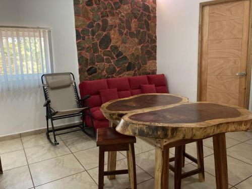 a living room with two wooden tables and a red couch at Palmas de Chahue in Santa Cruz Huatulco