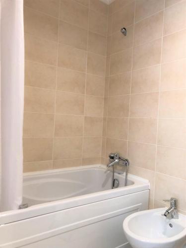 a bathroom with a white tub and a sink at Sea Avenue House - center Baleal - walk to surf in Ferrel