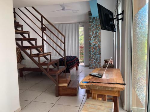 a living room with a staircase and a table at Palmas de Chahue in Santa Cruz Huatulco