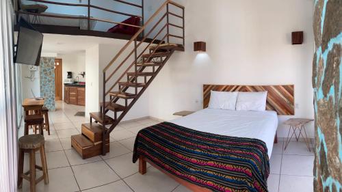 a bedroom with a bed and a spiral staircase at Palmas de Chahue in Santa Cruz Huatulco
