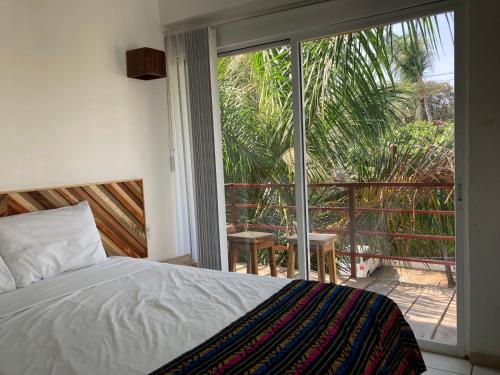 a bedroom with a bed and a sliding glass door at Palmas de Chahue in Santa Cruz Huatulco