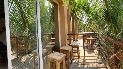 a balcony with a table and chairs and palm trees at Palmas de Chahue in Santa Cruz Huatulco