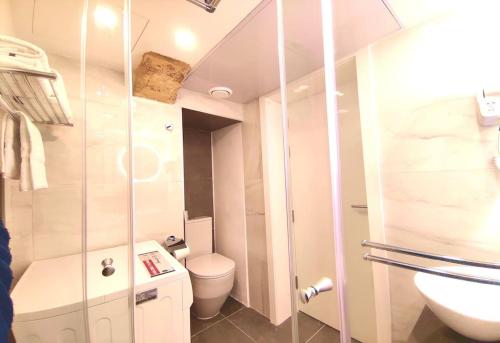 a bathroom with a toilet and a glass shower at Ripple 23 Savynomad Harbour Residences in Valletta