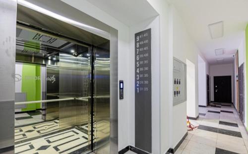 a hallway with a glass door in a building at Уютная квартира в центре левого берега in Taldykolʼ