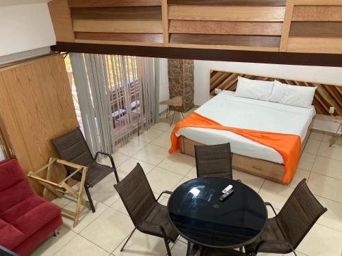 a bedroom with a bed and a table and chairs at Palmas de Chahue in Santa Cruz Huatulco