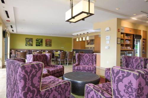 リッジランドにあるTownePlace Suites by Marriott Jackson Ridgeland/The Township at Colony Parkの紫色の椅子とテーブルが備わるバー
