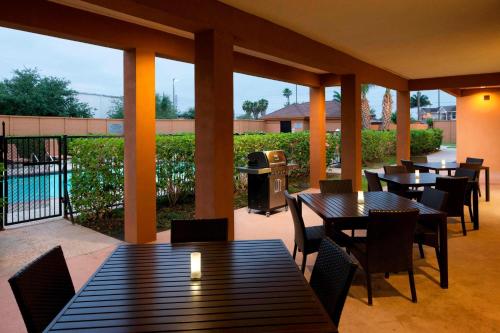 a patio with tables and chairs and a grill at Courtyard by Marriott Brownsville in Brownsville