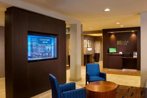 a lobby with a waiting area with blue chairs and a table at Courtyard by Marriott Brownsville in Brownsville