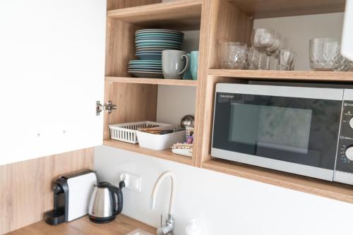 a kitchen counter with a microwave in a kitchen at Konik Morski in Jastarnia