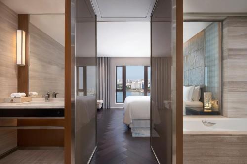 a bathroom with a bed and a tub and a sink at The Westin Haikou in Haikou