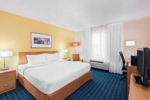 een hotelkamer met een bed en een flatscreen-tv bij Fairfield Inn & Suites by Marriott Springdale in Springdale
