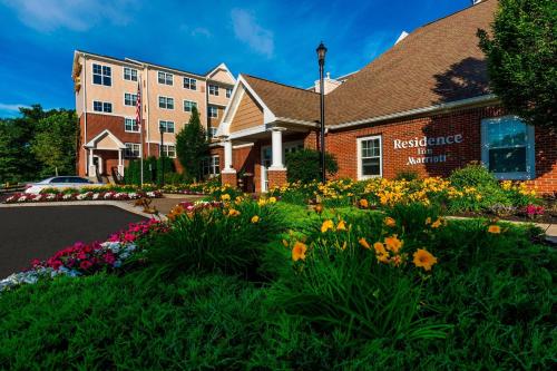 a hotel with flowers in front of a building at Residence Inn Worcester in Worcester