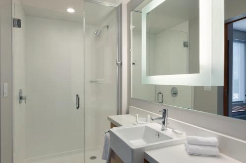 a white bathroom with a sink and a shower at SpringHill Suites by Marriott Houston Northwest in Houston