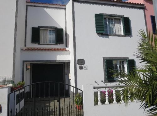 um edifício branco com duas janelas e um portão em Silvia's House em Ponta Delgada