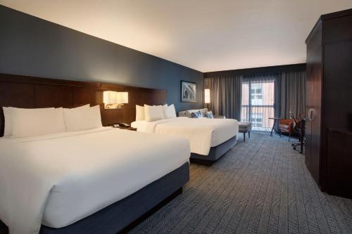 um quarto de hotel com duas camas e uma secretária em Courtyard Worcester em Worcester