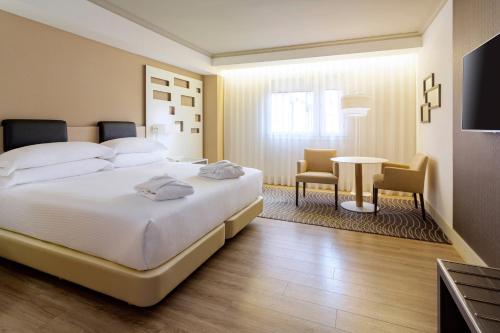 A bed or beds in a room at Madrid Marriott Auditorium Hotel & Conference Center