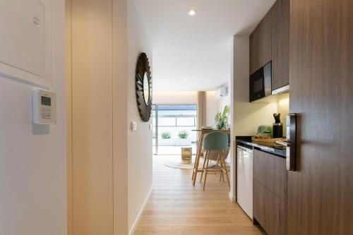 a hallway leading to a kitchen with a clock on the wall at Marinha Grande apartamentos N5 ICE in Marinha Grande