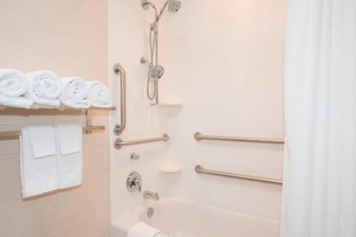 a bathroom with a shower and a toilet and towels at Fairfield Inn & Suites by Marriott Fredericksburg Texas in Fredericksburg