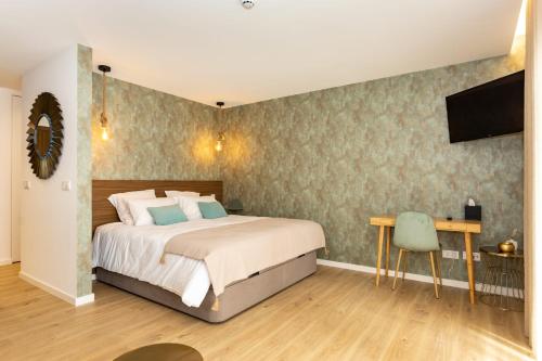 Un dormitorio con una cama, un escritorio y un televisor. en Marinha Grande apartamentos N5 ICE, en Marinha Grande