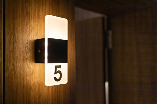 a white lightswitch on a wooden door with the number five at Marinha Grande apartamentos N5 ICE in Marinha Grande