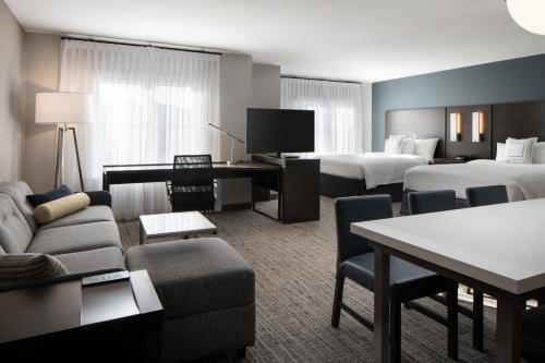 a hotel room with two beds and a living room at Residence Inn by Marriott Boulder Canyon Boulevard in Boulder