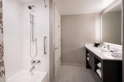baño blanco con ducha y lavamanos en Residence Inn by Marriott Boulder Canyon Boulevard, en Boulder