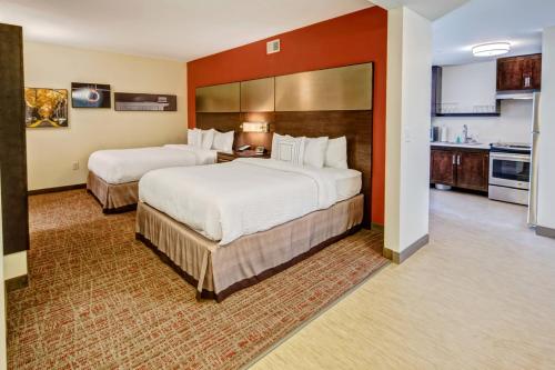 a hotel room with two beds and a kitchen at Residence Inn by Marriott Blacksburg-University in Blacksburg