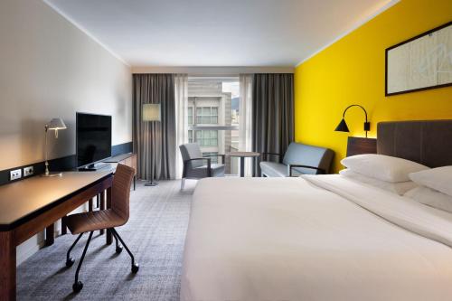 a hotel room with a bed and a desk at Four Points Sheraton Bolzano Bozen in Bolzano