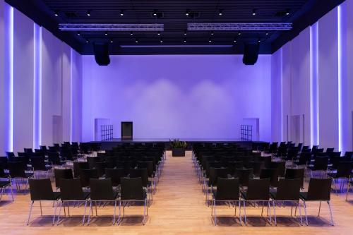 a large room with black chairs and a purple wall at Four Points Sheraton Bolzano Bozen in Bolzano