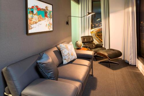 a living room with a leather couch and two chairs at Le Meridien Columbus, The Joseph in Columbus