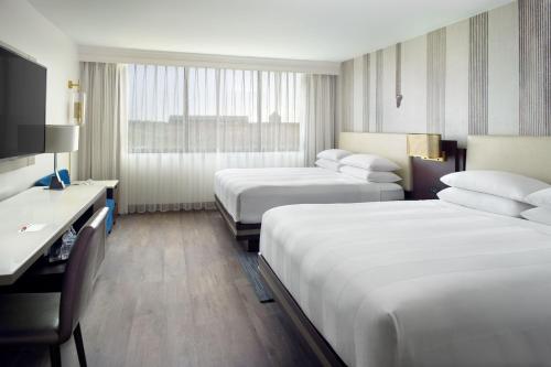 a hotel room with two beds and a desk at Marriott Kansas City Overland Park in Overland Park