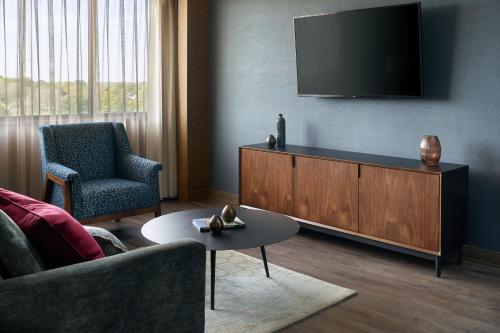 a living room with a flat screen tv on a wall at Marriott Kansas City Overland Park in Overland Park