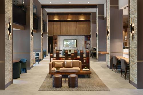 a lobby with a couch and tables and chairs at Marriott Kansas City Overland Park in Overland Park