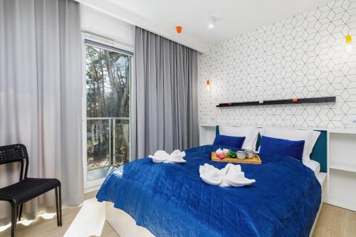 a bedroom with a blue bed with white shoes on it at 3-bedroom Apartment - Lesne Tarasy by Renters Prestige in Dziwnówek