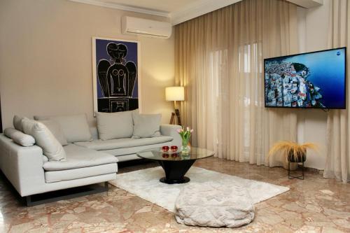 sala de estar con sofá y TV en Noema Urban Apartment, en Kavala
