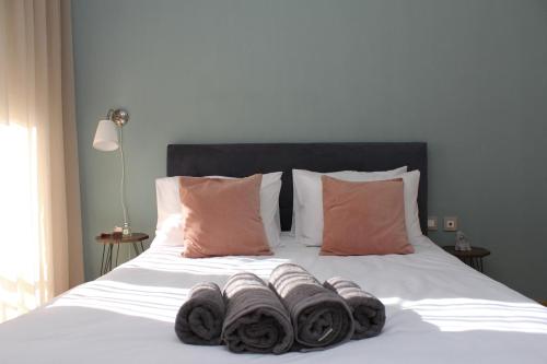 Una cama con toallas apiladas encima. en Noema Urban Apartment, en Kavala