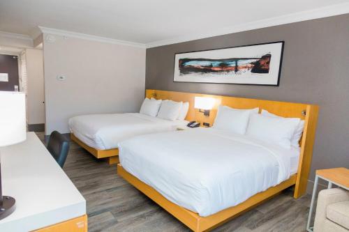 2 camas en una habitación de hotel con sábanas blancas en Delta Hotels Columbia Northeast, en Columbia