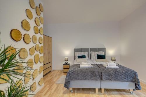 a bedroom with a bed and a wall with logs at Apartament Abra 2 Rynek 8 in Muszyna