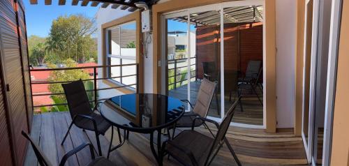 a patio with a glass table and chairs on a balcony at Palmas de Chahue in Santa Cruz Huatulco