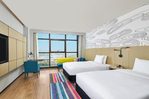 a hotel room with two beds and a tv at Aloft Shijiazhuang in Shijiazhuang