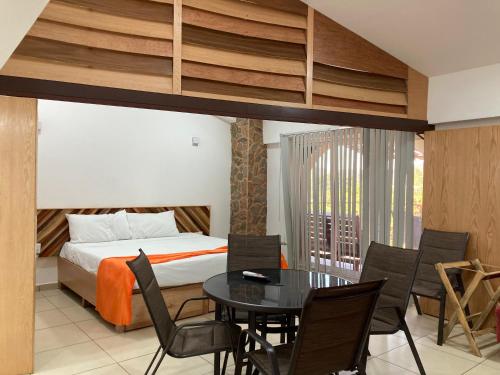 a bedroom with a bed and a table and chairs at Palmas de Chahue in Santa Cruz Huatulco