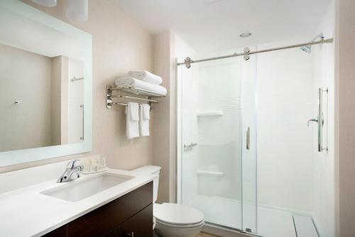 a bathroom with a shower and a sink and a toilet at TownePlace Suites by Marriott Alexandria Fort Belvoir in Woodlawn