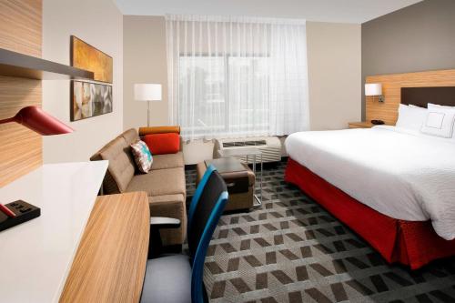 WoodlawnにあるTownePlace Suites by Marriott Alexandria Fort Belvoirのベッドとソファ付きのホテルルーム
