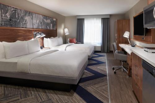 a hotel room with two beds and a desk at Four Points by Sheraton Vaughan in Vaughan