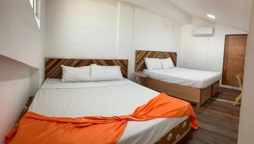 a small room with two beds in it at Palmas de Chahue in Santa Cruz Huatulco