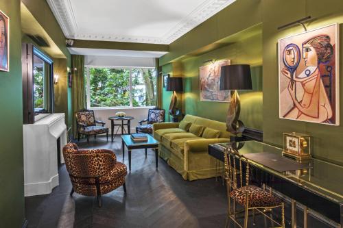Hôtel de Berri Champs-Élysées, a Luxury Collection Hotel في باريس: غرفة معيشة بجدران خضراء وأريكة صفراء