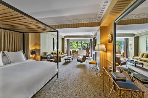 パリにあるHôtel de Berri Champs-Élysées, a Luxury Collection Hotelのベッドとリビングルームが備わるホテルルームです。